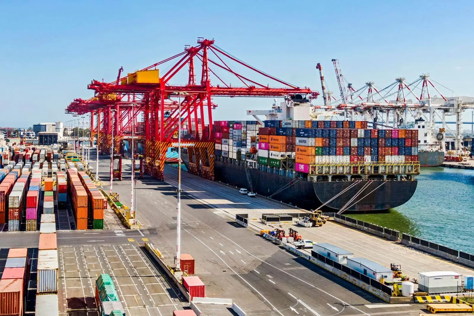Cargo ship loaded with shipping containers at a busy port terminal